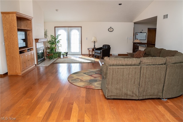 living room featuring lofted ceiling and wood-type flooring