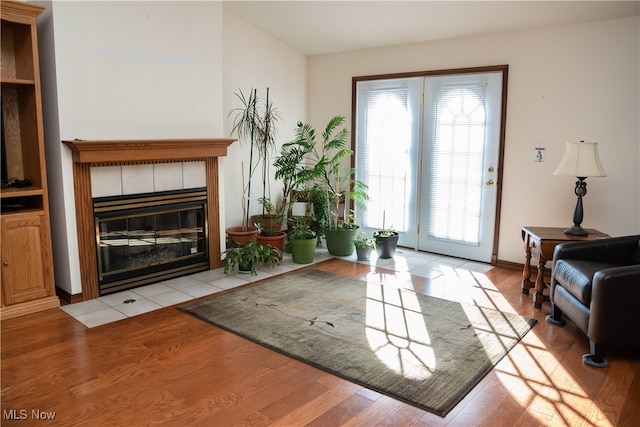 living room with light hardwood / wood-style floors and a tiled fireplace