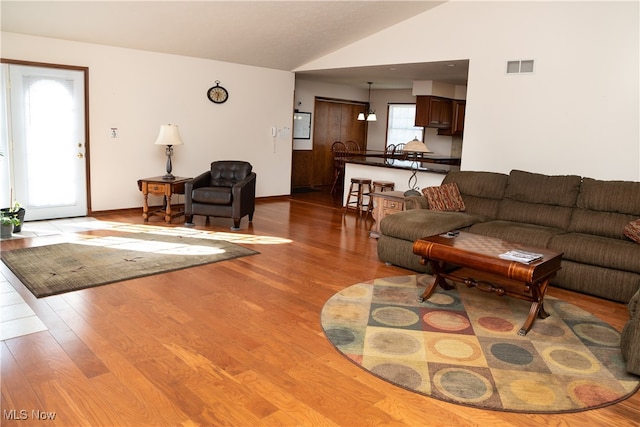 living room featuring lofted ceiling and light hardwood / wood-style flooring