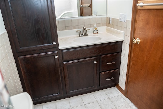 bathroom with tile walls, tile patterned flooring, and vanity