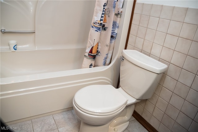 bathroom featuring toilet, tile walls, and shower / bath combo
