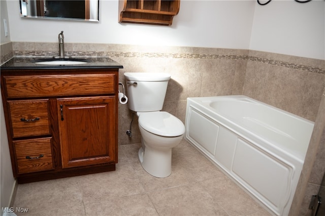 bathroom with a bath, tile patterned flooring, toilet, and vanity