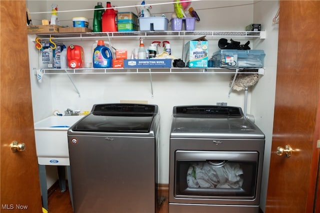 clothes washing area featuring sink and separate washer and dryer