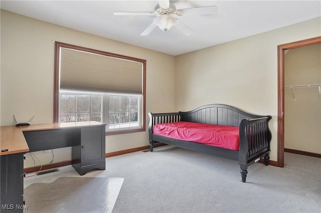 carpeted bedroom with a spacious closet and ceiling fan