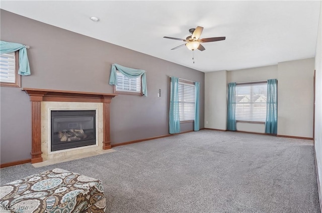 unfurnished living room with ceiling fan, a tile fireplace, and carpet floors