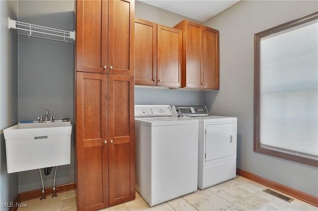 laundry room featuring sink, cabinets, and washer and clothes dryer