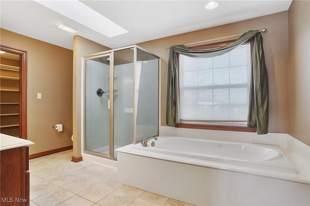 bathroom featuring vanity, tile patterned flooring, a skylight, and independent shower and bath