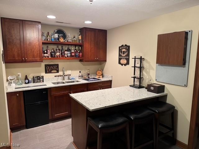 bar with sink and light stone countertops