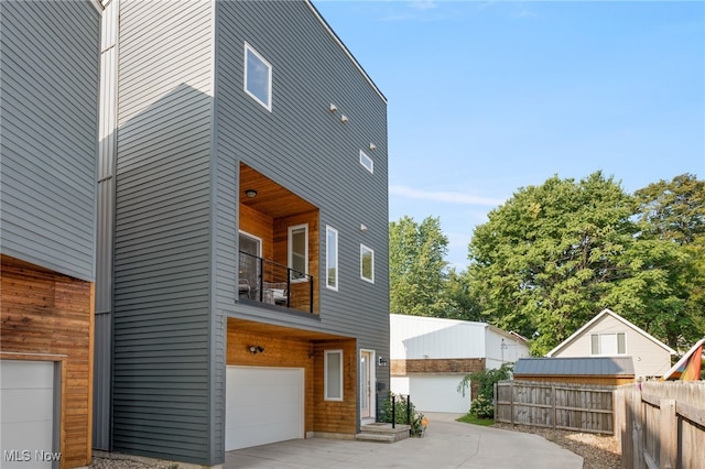 view of side of home with a garage and a balcony