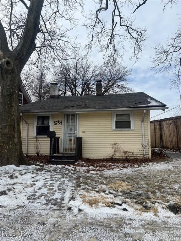 view of front of property with a chimney and fence