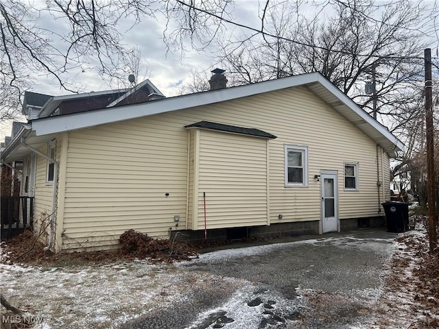 snow covered property with a chimney