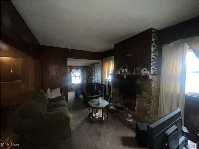 living room featuring a stone fireplace and carpet floors