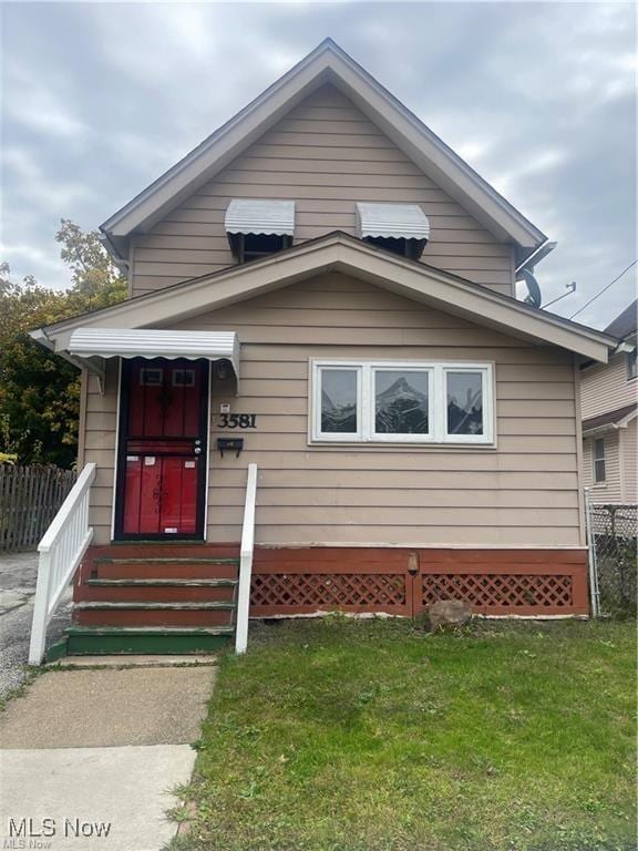 bungalow-style house featuring a front lawn