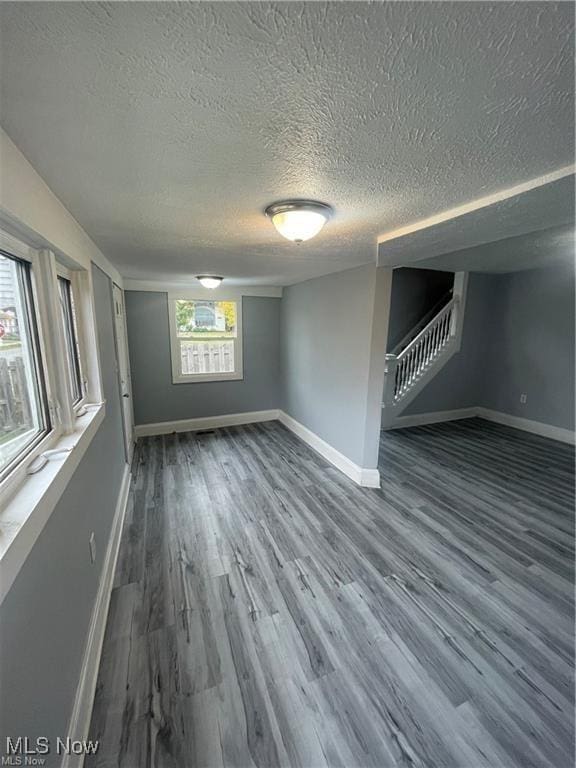 spare room with a textured ceiling and wood-type flooring