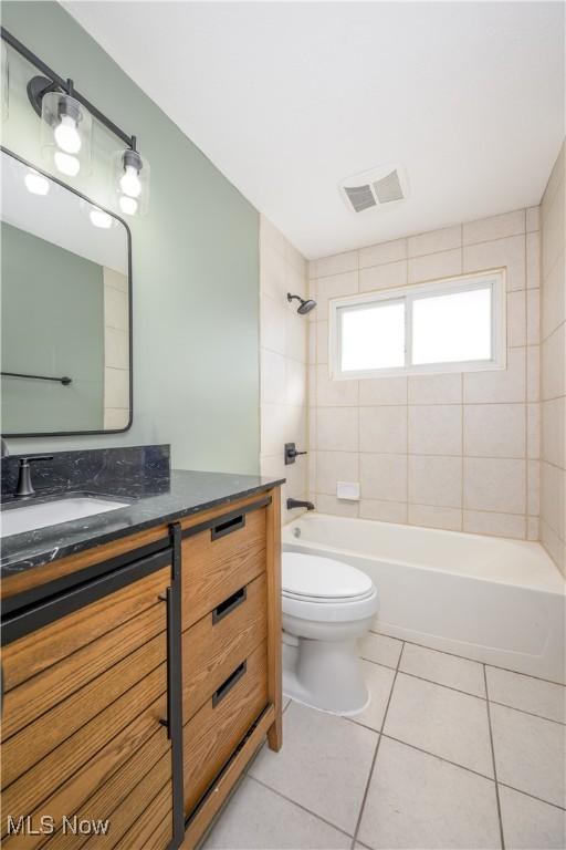 full bathroom featuring tile patterned floors, toilet, vanity, and tiled shower / bath