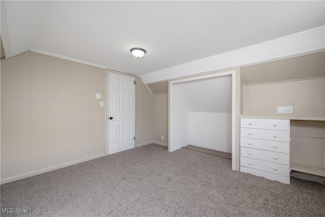 unfurnished bedroom featuring light carpet, vaulted ceiling, and a closet