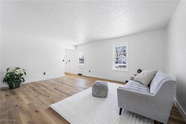 living area with a textured ceiling and hardwood / wood-style floors