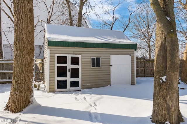 snow covered structure with a garage