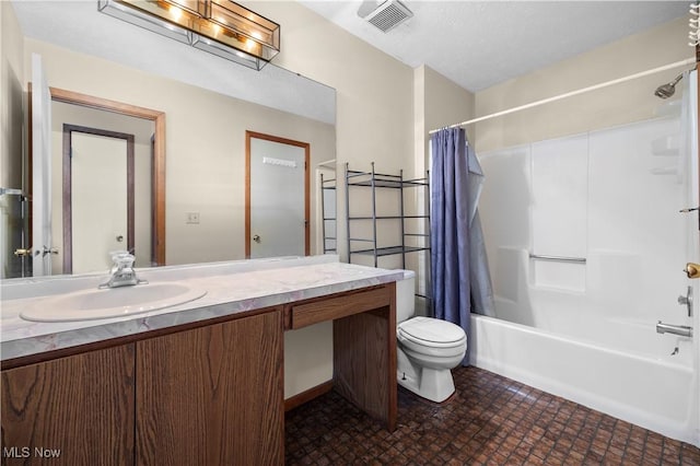 full bathroom featuring a textured ceiling, shower / tub combo, vanity, and toilet