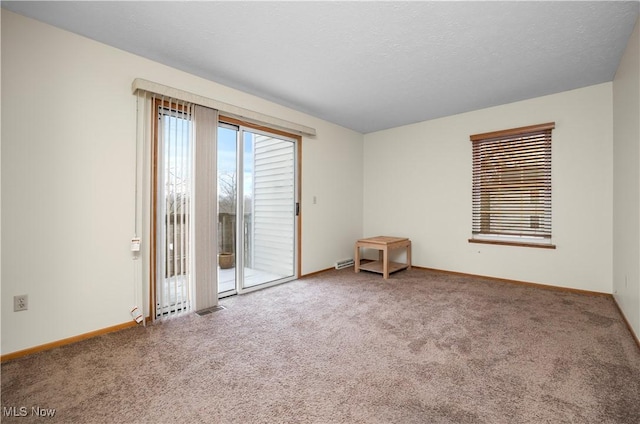 carpeted spare room with a textured ceiling