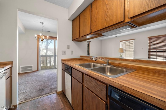 kitchen featuring dark colored carpet, decorative light fixtures, a wealth of natural light, sink, and dishwasher