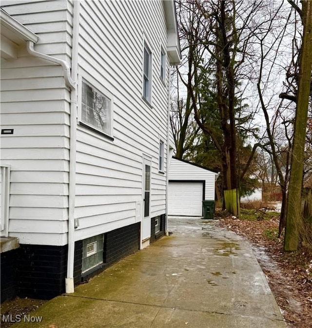 view of side of home featuring a garage and an outdoor structure