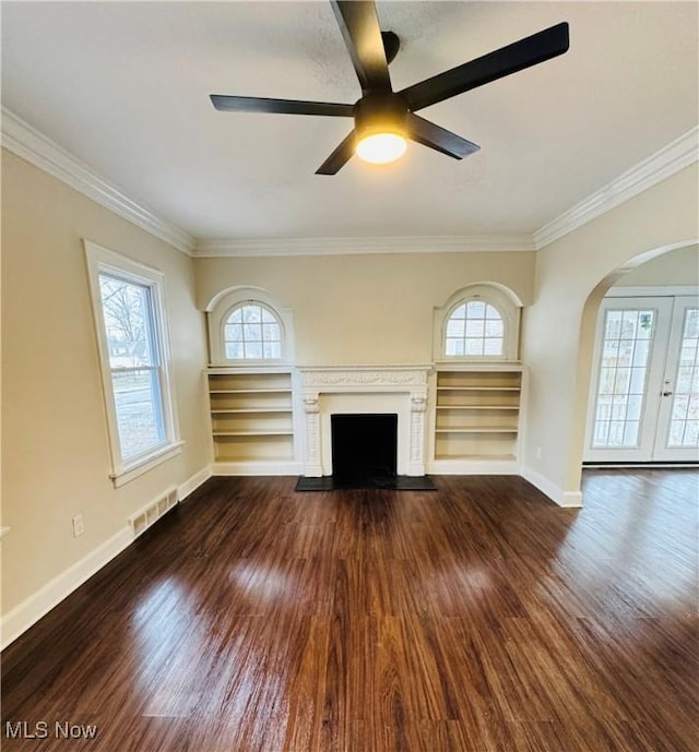 unfurnished living room with ceiling fan, crown molding, dark hardwood / wood-style floors, and french doors