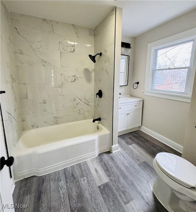 full bathroom with toilet, hardwood / wood-style flooring, vanity, and tiled shower / bath