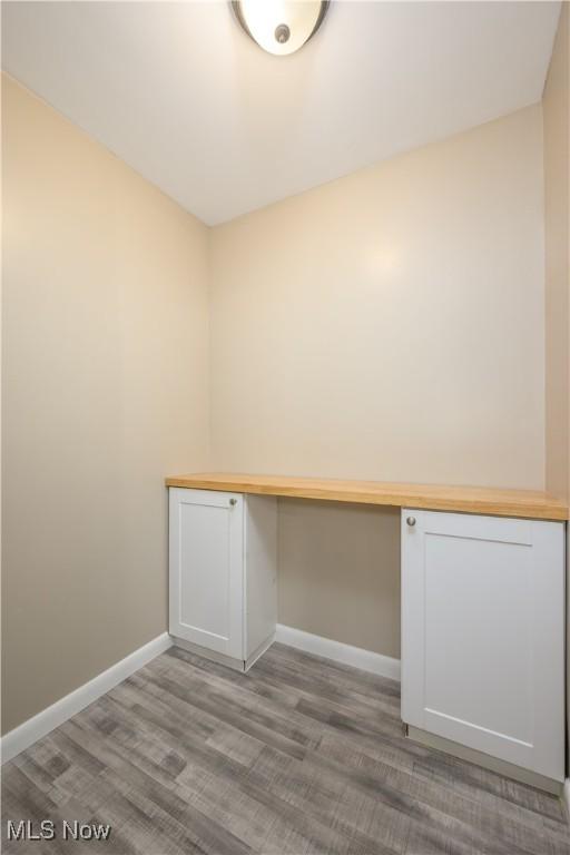 unfurnished office featuring light wood-type flooring and built in desk