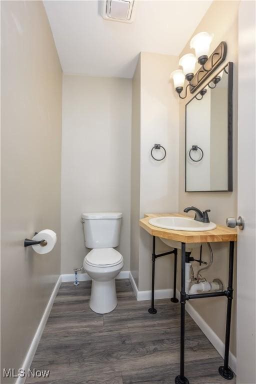 bathroom with hardwood / wood-style floors, sink, and toilet