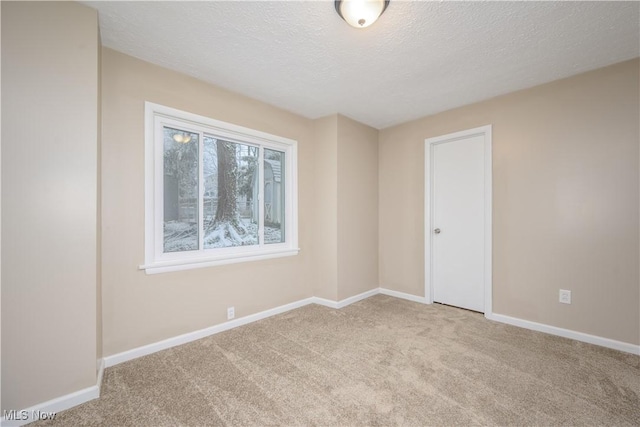 carpeted spare room with a textured ceiling