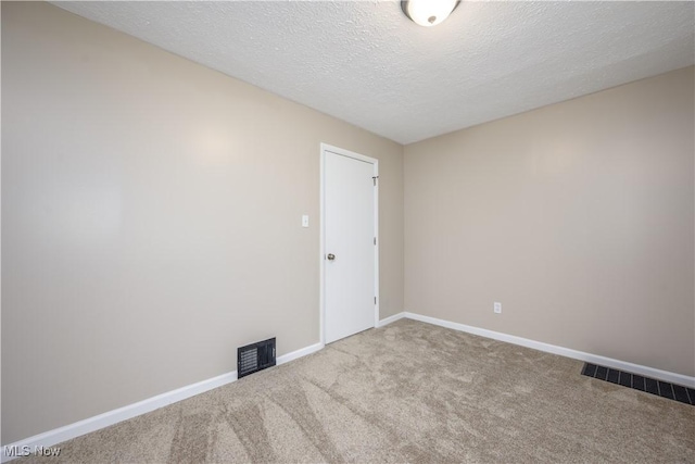 carpeted spare room featuring a textured ceiling