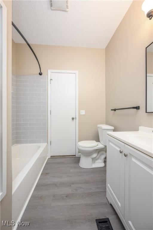 full bathroom featuring toilet, bathtub / shower combination, wood-type flooring, and vanity