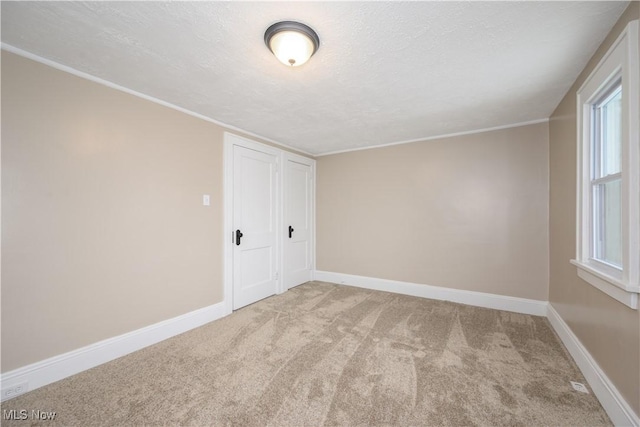 empty room featuring light carpet and a textured ceiling