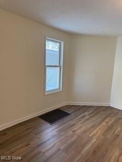 spare room featuring dark wood-type flooring