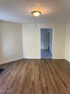 spare room with dark wood-type flooring