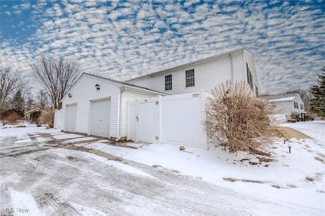 snow covered property with a garage