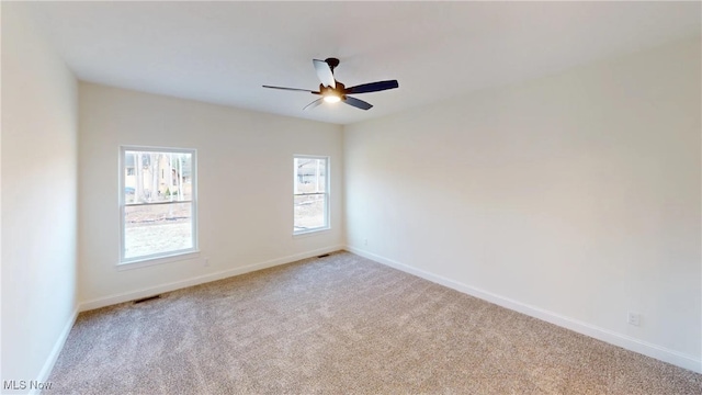 carpeted spare room with ceiling fan
