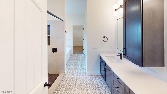 bathroom featuring vanity, tile patterned flooring, and a shower