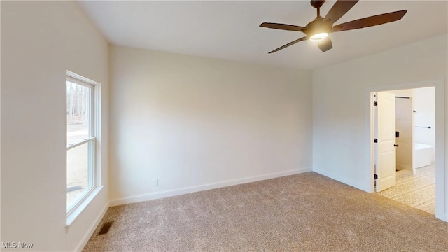 carpeted spare room featuring ceiling fan