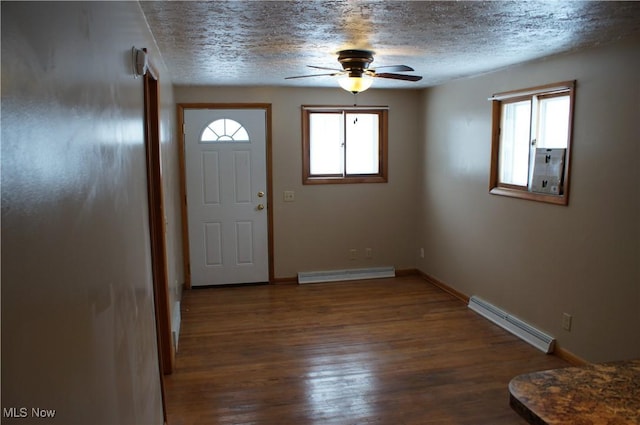 entrance foyer featuring a baseboard heating unit, dark wood-style flooring, a baseboard radiator, and a wealth of natural light