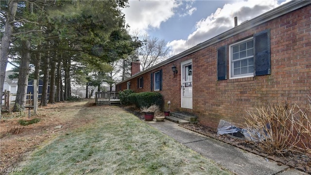 view of side of property with a deck and a lawn