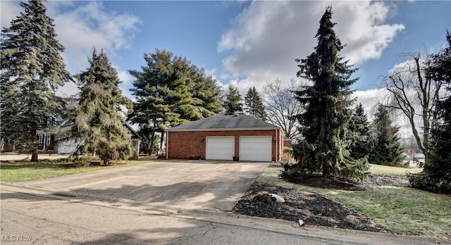 view of front of house featuring a garage and an outbuilding