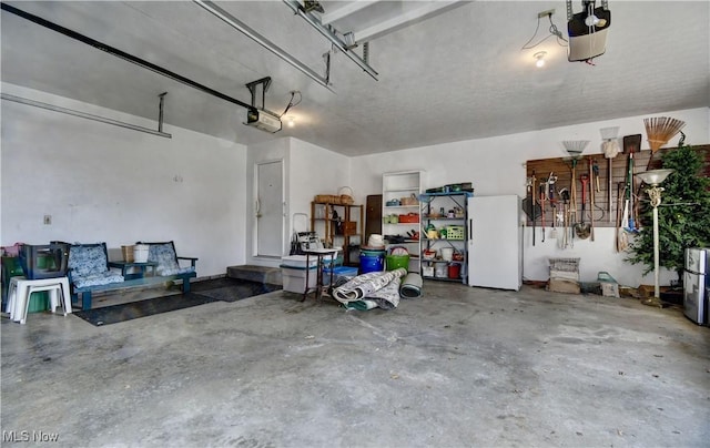 garage featuring a garage door opener and white refrigerator