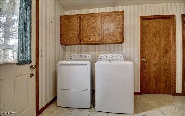 washroom featuring cabinets, washer and dryer, and light tile patterned floors