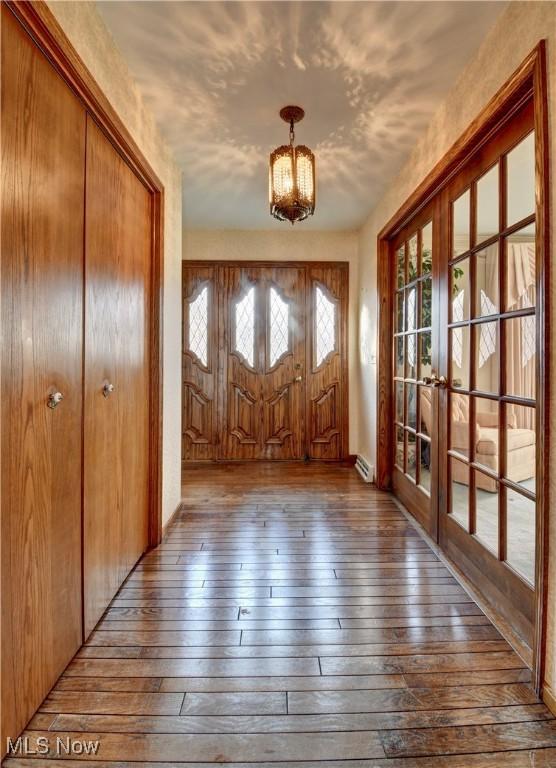 entrance foyer featuring a baseboard radiator, french doors, and hardwood / wood-style flooring