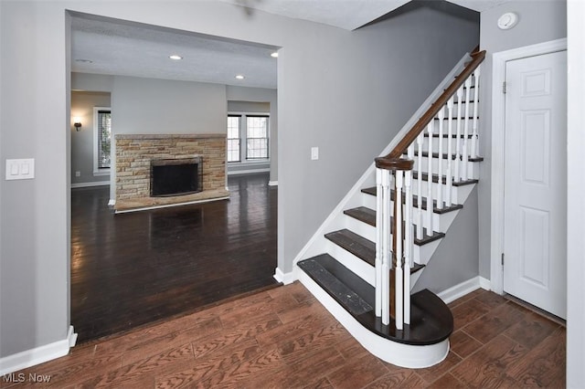 stairway featuring hardwood / wood-style floors and a fireplace