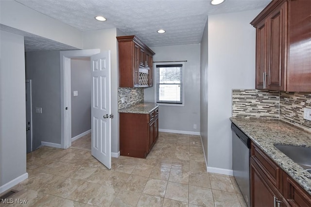 kitchen with light stone countertops, a textured ceiling, stainless steel dishwasher, decorative backsplash, and sink