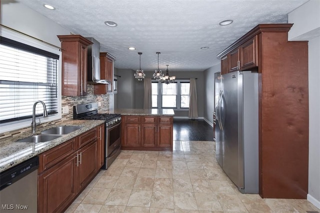 kitchen with appliances with stainless steel finishes, sink, wall chimney range hood, kitchen peninsula, and hanging light fixtures