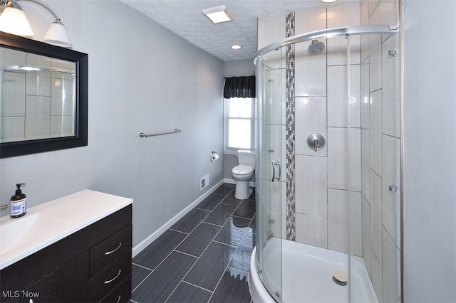 bathroom featuring a textured ceiling, vanity, toilet, and walk in shower